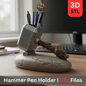 May include: A grey hammer-shaped pen holder with a brown handle and a dragon head detail. The pen holder is on a stone-like base and holds several pens and pencils. The image includes the text "Hammer Pen Holder | STL Files".