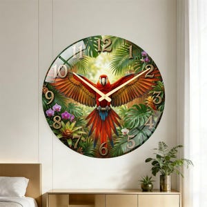 May include: Round wall clock featuring a vibrant parrot with outstretched wings, set against a backdrop of lush green foliage and flowers. The clock face has gold numerals and hands, creating a decorative and functional piece.
