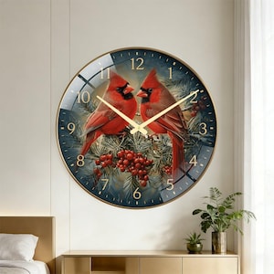 May include: A round wall clock with a gold frame featuring a printed image of two red cardinal birds perched on pine branches with red berries. The clock face has gold-colored hands and gold-colored numerals from one to twelve.