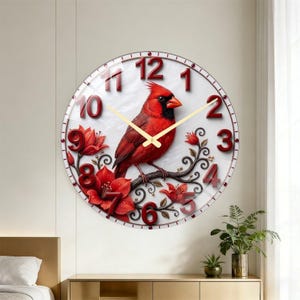 May include: A round wall clock featuring a vibrant red cardinal bird perched on a branch with red flowers. The clock face has a white background with large, raised red numerals from 1 to 12 and thin gold-colored hour and minute hands.
