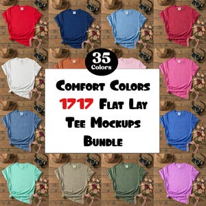 May include: A flat lay mockup bundle showcasing 35 colours of Comfort Colors t-shirts. The shirts are arranged on a wooden surface with props such as cameras, hats, and flowers. The image text reads "Comfort Colors 1717 Flat Lay Tee Mockups Bundle."