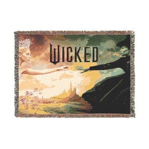 Peut inclure: Plaid tissé avec des illustrations de la comédie musicale "Wicked". Le motif représente deux personnages se tendant la main, avec le mot "Wicked" en lettres grasses. La palette de couleurs comprend des nuances de vert, de jaune et de noir.