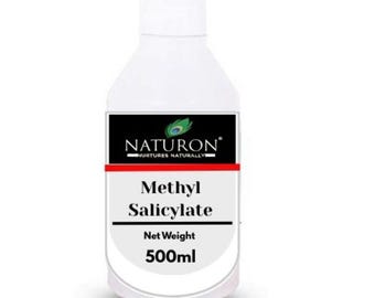 Puede incluir: Una botella blanca de salicilato de metilo con una etiqueta en blanco y negro. La etiqueta presenta la marca "NATURON" y el texto "Nurtures Naturally". La botella contiene 500 ml de producto.