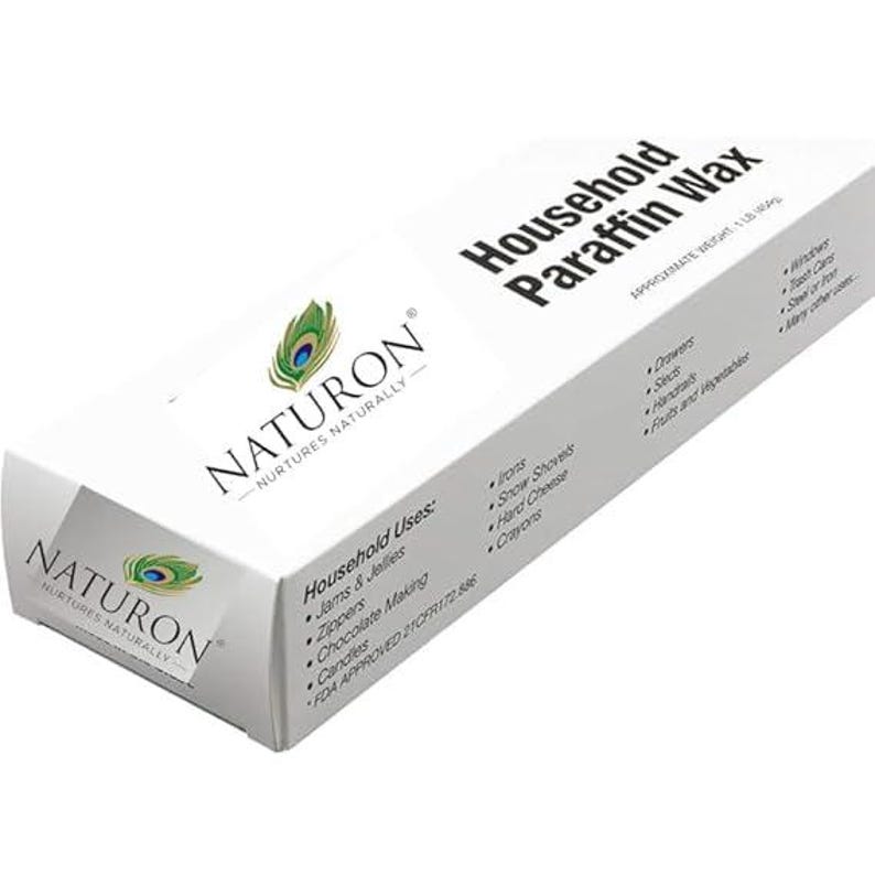 Puede incluir: Una caja blanca de cera de parafina dom&eacute;stica Naturon. La caja presenta un logotipo de pluma de pavo real y texto que indica usos dom&eacute;sticos como para planchas, cremalleras y elaboraci&oacute;n de chocolate. El peso aproximado es de 454 g.