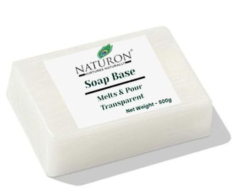May include: A rectangular block of transparent soap base with a white label. The label reads "NATURON" and "Soap Base" with the words "Melts & Pour Transparent" below. The net weight is 500g.
