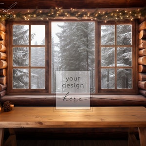 Peut inclure: Une table en bois avec un fond de cabane en rondins rustique. Une fenêtre avec vue sur une forêt enneigée est décorée d'une guirlande lumineuse. La table est parfaite pour présenter vos produits ou designs.