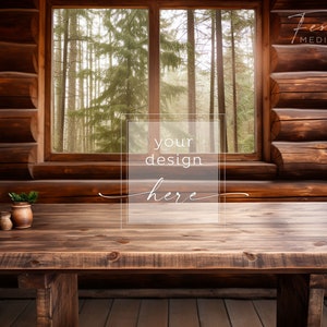 May include: A rustic wooden table with a wood grain finish sits in front of a window with a view of a forest. The table is empty except for a small potted plant and two salt shakers. The text "your design here" is superimposed on the image.