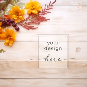 May include: A wooden background with a border of yellow and orange flowers, red berries, and green leaves. The text "your design here" is in a black frame in the center of the image.