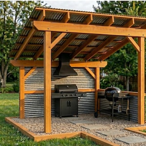 Könnte beinhalten: Eine Außenküchenstruktur mit Holzrahmen sowie Dach und Rückwand aus Wellblech. Sie umfasst einen schwarzen Gasgrill mit passender Abzugshaube und einen separaten schwarzen Holzkohle-Kugelgrill auf einer Fläche aus Kies.