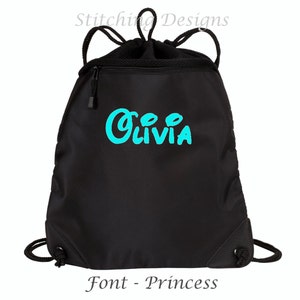 May include: Black drawstring bag with a zippered pocket and a turquoise blue embroidered name "Olivia" in a princess font.