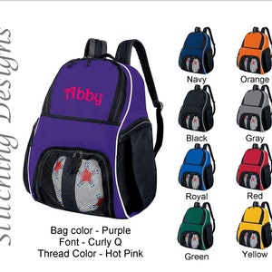 May include: Purple backpack with the name "Abby" embroidered in hot pink. The bag has a mesh pocket holding a soccer ball. Additional color options include navy, orange, black, gray, royal blue, red, green, and yellow.