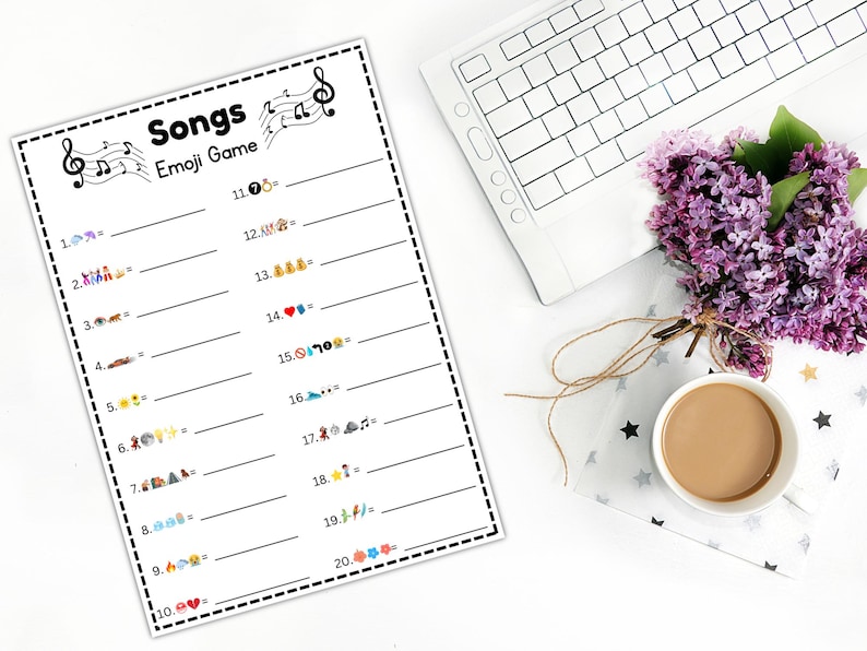 Peut inclure: Une feuille blanche imprim&eacute;e avec le jeu "Songs Emoji Game", des notes de musique et des lignes num&eacute;rot&eacute;es pour les r&eacute;ponses. Un clavier blanc, une tasse de caf&eacute; et un bouquet de fleurs violettes sont &eacute;galement dans l'image.