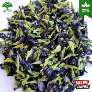 May include: A pile of dried butterfly pea flowers featuring deep indigo blue petals and pale green calyxes. The image includes a logo with a tree icon and the text NATURE monstera, a green banner with 100% ORGANIC, and a red shipping icon.