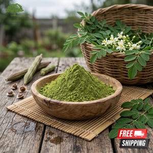 May include: A wooden bowl of green moringa powder on a bamboo mat. A wicker basket contains moringa leaves and white flowers. Moringa pods and seeds are arranged on a weathered wooden table. The image has a natural, organic aesthetic.