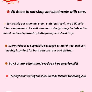 May include: A light pink informational graphic titled About Us featuring red apple illustrations. The text states that items are handmade using titanium steel, stainless steel, and 14K gold-filled components. It mentions packaging, a gift offer, and the shop name juicywear.