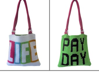May include: Two crocheted tote bags. One is white with the word "LIFE" in colorful letters. The other is green with the words "PAY DAY" in black. Both bags have pink handles and silver rings.