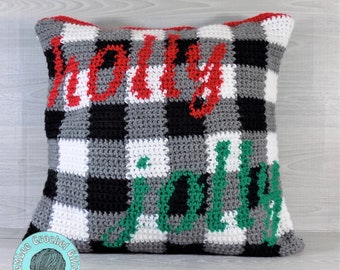 May include: A crocheted pillow with a black and white checkered pattern. The words "Holly Jolly" are written in red and green yarn on the pillow.