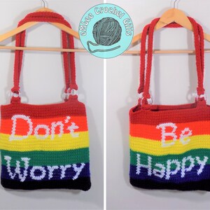 May include: Two crocheted tote bags with rainbow stripes and white lettering. One bag says "Don't Worry" and the other says "Be Happy".