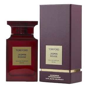 May include: A dark red perfume bottle and matching box. The bottle is rectangular with a rounded top and a gold label that reads "TOM FORD JASMIN ROUGE EAU DE PARFUM 100 ML." The box has the same label and text. The box also reads "EAU DE PARFUM VAPORISATEUR SPRAY 3.4 FL. OZ./OZ. LIQ./100 ml e."