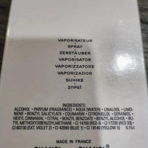 May include: A close-up of a white perfume box with black text. The box lists ingredients and phrases like "VAPORISATEUR" and "SPRAY". The Chanel logo is visible, along with "MADE IN FRANCE" and "COCO".