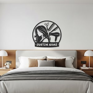 Puede incluir: Arte de pared de metal negro con la silueta del perfil de una mujer, herramientas de peluquería y el texto "CUSTOM NAME". El diseño incluye tijeras, un peine y un secador de pelo, ideal para un salón de belleza.