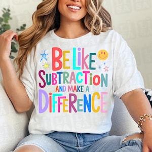 May include: White t-shirt with the text "BE LIKE SUBTRACTION AND MAKE A DIFFERENCE" in colorful letters. The design includes a smiley face, stars, and a starfish. The shirt is a casual, everyday wear item.