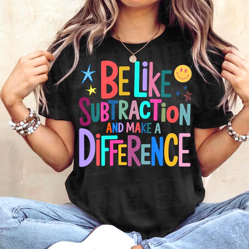 May include: Black t-shirt with the text "BE LIKE SUBTRACTION AND MAKE A DIFFERENCE" in colorful block letters. The shirt features a smiley face and star graphics. The shirt is a casual style.