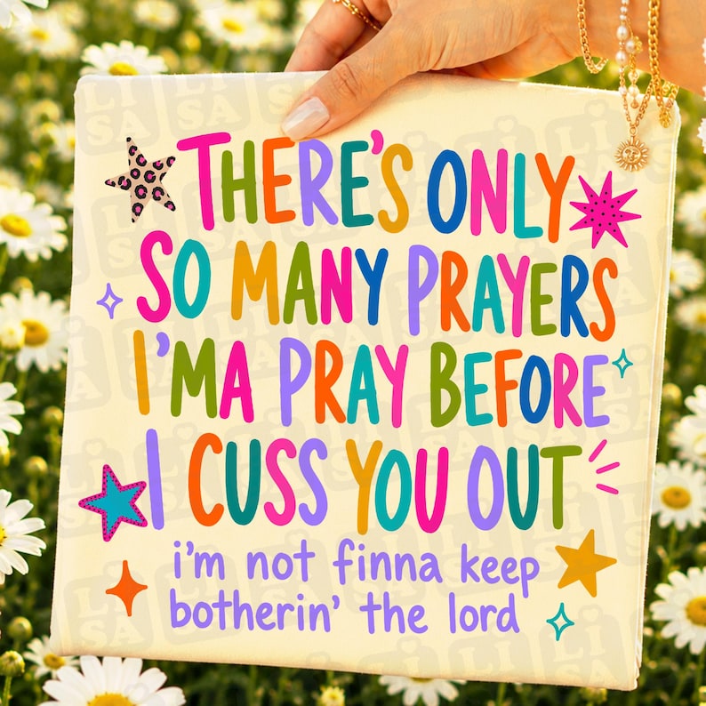 May include: A square off-white sign featuring colorful text that reads: THERE'S ONLY SO MANY PRAYERS I'MA PRAY BEFORE I CUSS YOU OUT i'm not finna keep botherin' the lord. The design includes various star shapes in pink, blue, and yellow.