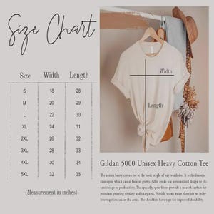 Op de afbeelding: Een maattabel voor een Gildan 5000 unisex zwaar katoenen t-shirt, met breedte- en lengtematen in inches voor de maten S tot 5XL. De afbeelding toont een beige t-shirt op een hanger met lijnen die aangeven waar de breedte en lengte worden gemeten.