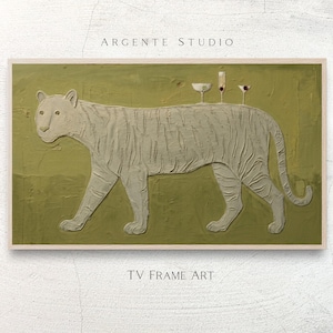 Puede incluir: Una obra de arte enmarcada que presenta un tigre texturizado de color claro sobre un fondo verde. Tres copas de cóctel están equilibradas sobre la espalda del tigre. El texto "ARGENTE STUDIO" y "TV FRAME ART" son visibles.