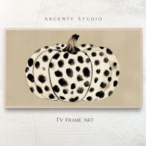 Op de afbeelding: Een rechthoekig ingelijst digitaal kunstwerk met een aquarelillustratie van een crèmekleurige pompoen met zwarte stippen en een donkere steel. De tekst ARGENTE STUDIO staat erboven en TV FRAME ART staat eronder afgebeeld.
