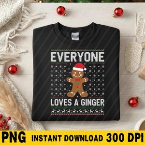 May include: Black sweatshirt with a festive design. The design includes the text "EVERYONE LOVES A GINGER" in white, along with a gingerbread man wearing a Santa hat. The design also features snowflakes and reindeer.