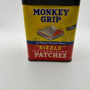 May include: Vintage Monkey Grip "Sizzle" Patches tin. The yellow tin features the text "MONKEY GRIP" and "PATCHES" in bold letters. The tin also has an illustration of a patch and the text "FITS ALL KNOWN".
