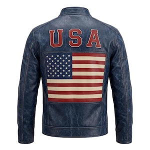 Könnte beinhalten: Eine blaue Lederjacke mit Used-Optik, Stehkragen und langen Ärmeln. Auf der Rückseite befindet sich der Schriftzug USA in roten Blockbuchstaben über einer großen, rechteckigen Grafik der amerikanischen Flagge in den Farben Rot, Weiß und Blau.