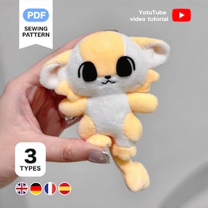 K&ouml;nnte beinhalten: Ein Pl&uuml;schtier in Form eines Zeichentricktiers, haupts&auml;chlich gelb und wei&szlig;, mit gro&szlig;en schwarzen Augen. Das Spielzeug wird in einer Hand gehalten. Der Text auf dem Bild lautet "PDF SEWING PATTERN", "YotuTube video tutorial" und "3 TYPES".