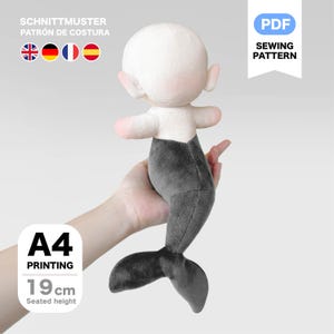 May include: A plush mermaid doll with a white head, pink arms, and a gray tail. The doll is 7.5 inches tall when seated. The image includes text that says "PDF Sewing Pattern" and "A4 Printing".