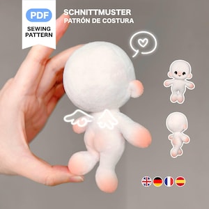 May include: A plush white angel doll with pink accents, small wings, and a round head. The image includes the text "PDF Sewing Pattern" and "SCHNITTMUSTER PATRÓN DE COSTURA". Additional small doll illustrations are also present.