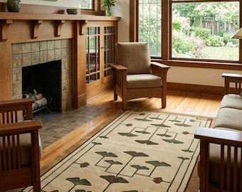 May include: A rectangular area rug featuring a cream-coloured background with a repeating geometric pattern of dark green and brown stylised ginkgo leaf motifs, framed by a dark brown border with small rectangular accents in the corners.