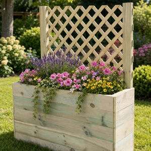 Può includere: Una fioriera rettangolare in legno con un pannello posteriore a traliccio. Il contenitore è riempito con lavanda viola, petunie rosa, fiori gialli ed edera verde, mostrando le venature naturali del legno con sfumature verde chiaro.