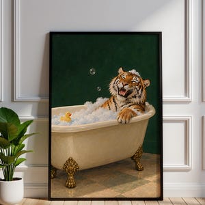 May include: A framed wall art print featuring a tiger sitting in a cream-coloured clawfoot bathtub filled with white soap bubbles. A small yellow rubber duck floats in the bubbles. The background is a solid dark green colour.