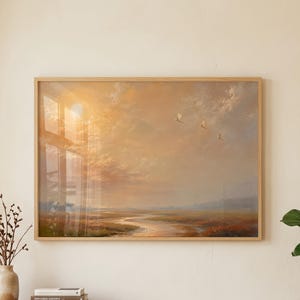 Könnte beinhalten: Ein rechteckiges Landschaftsgemälde in einem hellen Holzrahmen, das eine Sumpflandschaft bei Sonnenuntergang mit goldenem Licht, weichen Wolken und drei in der Ferne fliegenden Vögeln zeigt. Das Kunstwerk besticht durch warme Orange-, Gelb- und Blautöne.