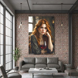 May include: A framed canvas print depicting a woman with red hair and a glass of red wine. The artwork is displayed on a brick wall above a grey sofa in a modern living room. The room has large windows and industrial-style lighting fixtures.