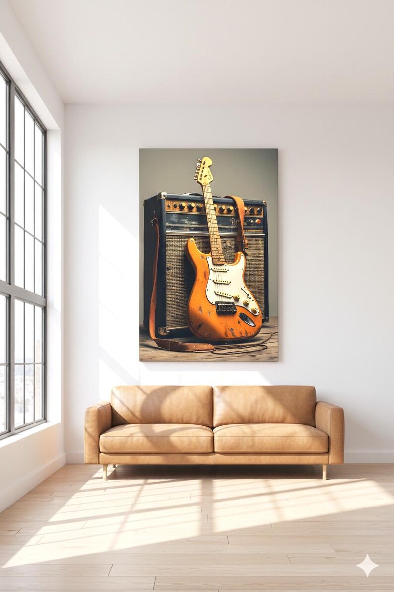 May include: An orange electric guitar with a white pickguard and a brown leather strap leans against a black amplifier. The guitar has a distressed finish. The image is set in a room with a tan leather sofa and a large window.