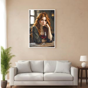 May include: A framed print shows a woman with flowing red hair, resting her chin on her hand, with a glass of red wine on a wooden table. The artwork is displayed in a living room with a white sofa and a potted plant.