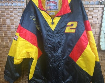 Könnte beinhalten: Eine Nutmeg NASCAR-Rennjacke mit einem schwarz-gelb-roten Color-Block-Design. Die Jacke verfügt über einen Frontreißverschluss, einen hohen Kragen und die gelbe Nummer 2 auf der Brust. Sie enthält eine Signatur und einen Zielflaggen-Aufnäher.