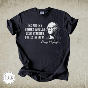 May include: Black t-shirt with the quote "ME AND MY HOMIES WOULDA BEEN STACKING BODIES BY NOW" and a portrait of George Washington. The text and portrait are in white. The word "BLACK" is in a white circle at the bottom.