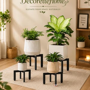 Peut inclure: Quatre supports de plantes en métal noir de hauteurs variées, chacun portant une plante en pot. Les pots sont blancs ou beiges et contiennent du feuillage vert. Le texte en haut indique DecoretteHome ELEVATE YOUR SPACE, NATURALLY. Le texte en bas inclut Sturdy Metal Stand, Adjustable & Stable, Stylish Modern Design, Perfect for Any Space.