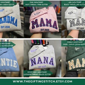 May include: Embroidered sweatshirts in various colors, including gray, pink, blue, and green. Each sweatshirt features a different name, such as "Grandma," "Mama," and "Auntie," with the year embroidered below. The website address is also visible.