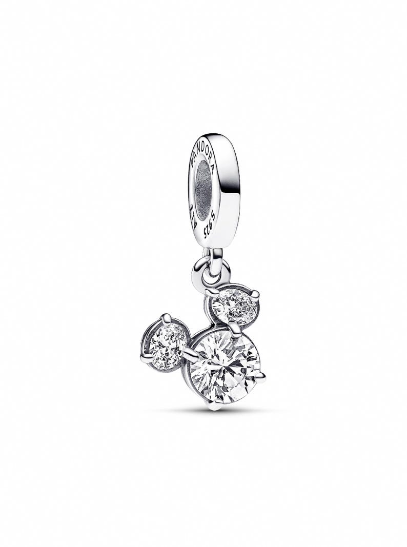 A silver-toned charm bracelet with a pendant featuring three round diamonds.