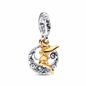 Könnte beinhalten: Ein silberner und goldener Charm-Anhänger mit einer Feenfigur. Der Charm hat eine goldene Feensilhouette vor einem silbernen Mond und Sternen-Design. Der Charm hängt an einem silbernen Ring mit floralen und textlichen Details.